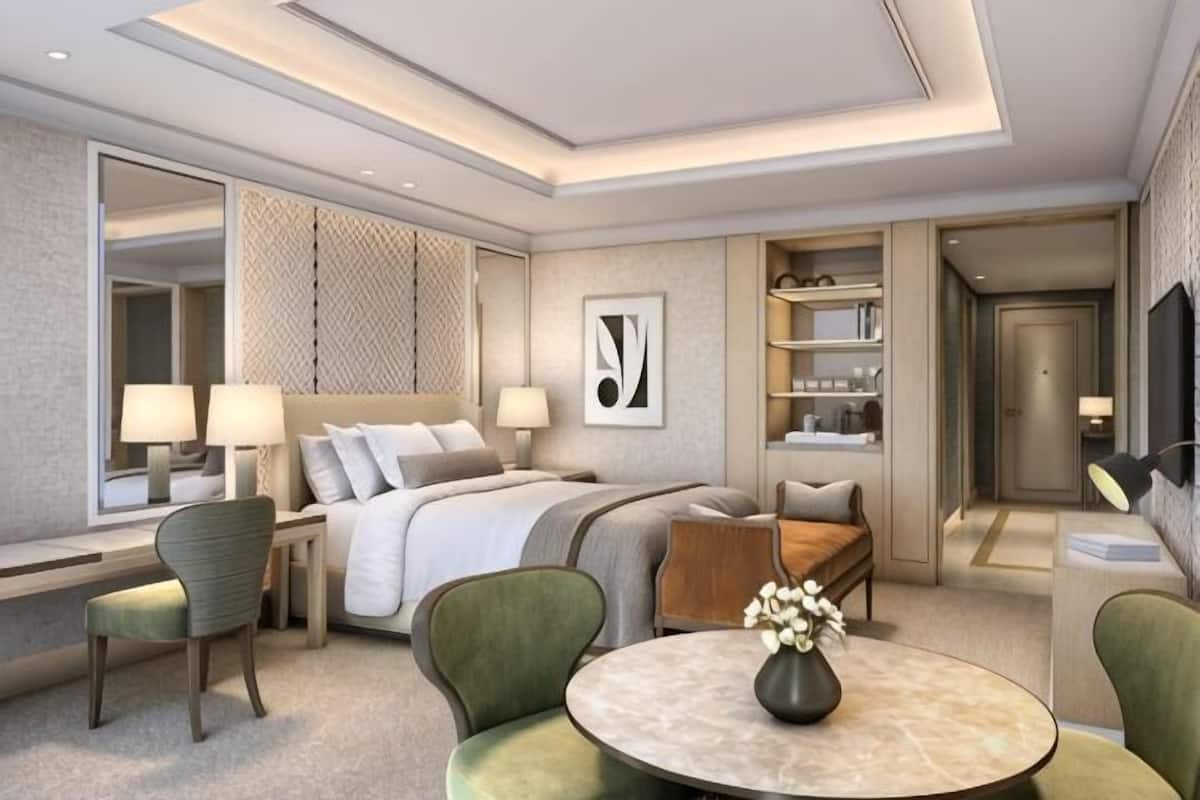 Ein modernes Hotelzimmer mit Bett, Sitzecke und Fernseher.