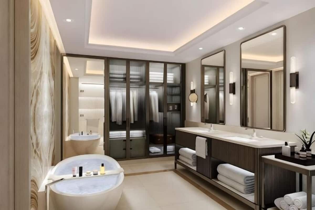 Ein modernes Badezimmer mit Badewanne, zwei Waschbecken, einem großen Spiegel und einem begehbaren Kleiderschrank.