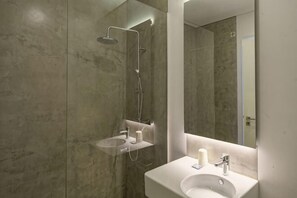 A modern bathroom with a shower, sink, and mirror. - N Apartments - Luís (Porto)