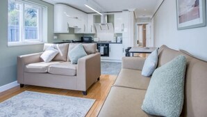 Un soggiorno moderno con un divano color beige, un tavolino da caffè e un tappeto decorato.