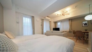 Habitación de hotel con una cama grande, un escritorio, una silla y una televisión.