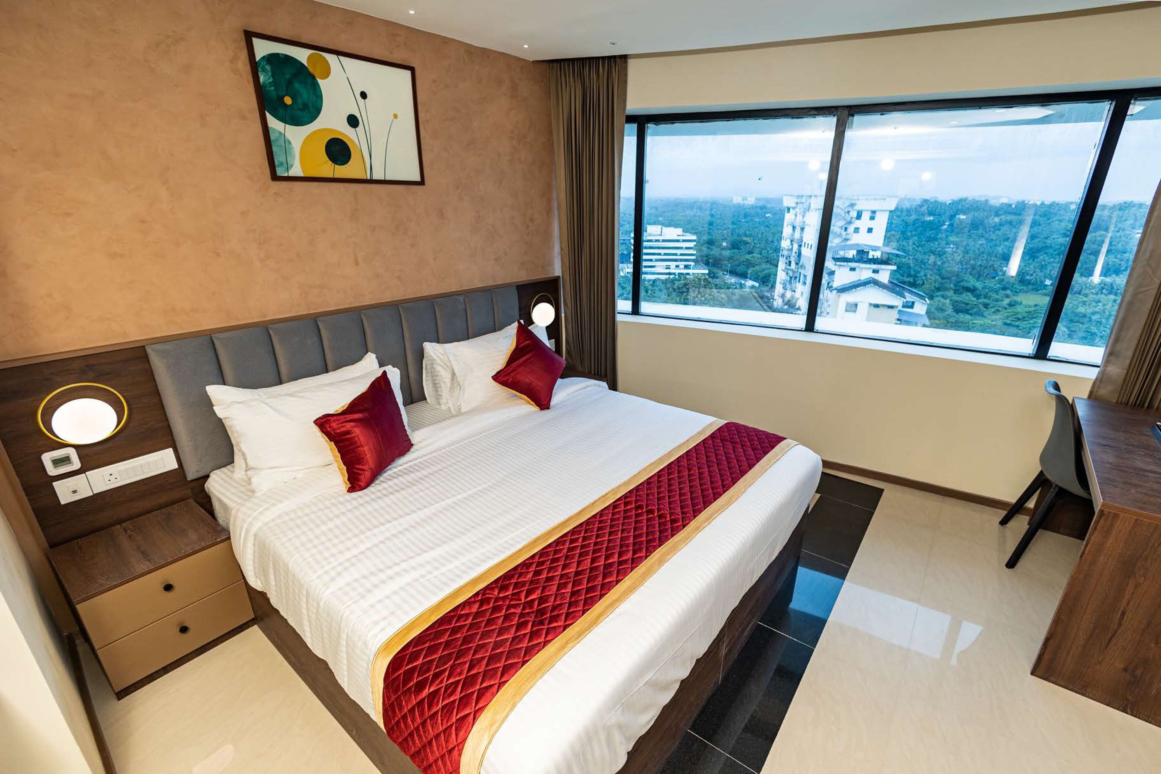 Una habitación de hotel con una cama grande, un escritorio y vistas a la ciudad.