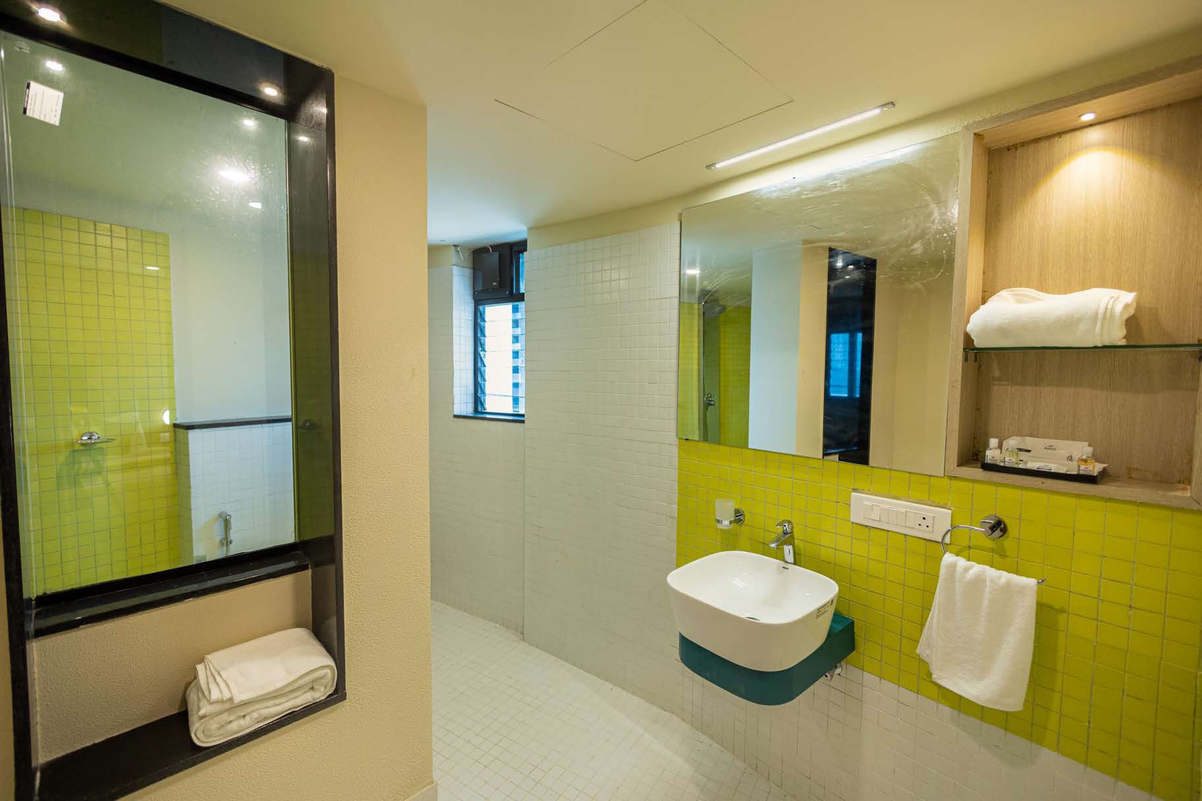 A bathroom with a white sink, a mirror, and a towel rack.