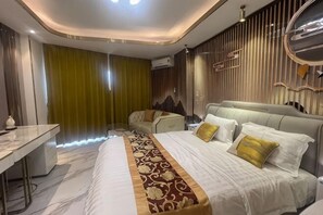 A modern bedroom with a large bed, a desk, and a seating area. - Pattaya Jomtien Vitala Luxury Golden Style Hotel Apartment (Next to Airport Bus Station) (Pattaya)