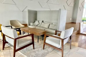 A modern living room with a sofa, two armchairs, and a coffee table. - KL Central 31st floor KLCC view (Kuala Lumpur)