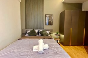 A bedroom with a bed, pillows, a bedside table with a lamp, and a wardrobe. - KL Central 31st floor KLCC view (Kuala Lumpur)