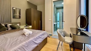 A modern hotel room with a bed, a desk, a chair, a mirror, and a wardrobe. - KL Central 31st floor KLCC view (Kuala Lumpur)