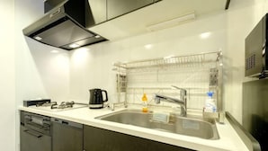 Une cuisine moderne dotée d’un évier à deux bacs, d’appareils électroménagers en acier inoxydable et d’un égouttoir à vaisselle.