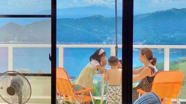 A terrace with a table and chairs overlooking a scenic view of mountains and a body of water. - Atami Tenku Villa Sky terrace (Atami)