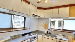 A kitchen with white cabinets, a stainless steel countertop, a gas stove, and a dishwasher. - Atami Tenku Villa Sky terrace (Atami)