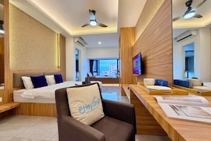 Een moderne hotelkamer met een bed, een bureau, een stoel en een televisie.