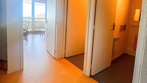 Een gang met een schuifdeur naar een balkon met uitzicht.