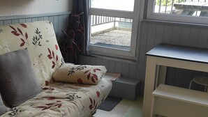 Una habitación acogedora con un sofá, una mesita y una ventana que da a vistas exteriores.