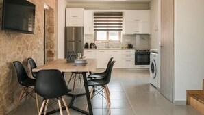 Een moderne keuken met witte kasten, een ingebouwde oven en een wasmachine.