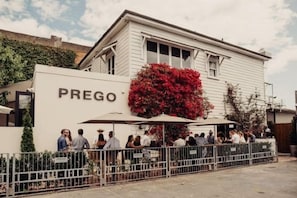 A building with a sign 'PREGO' and a group of people gathered outside. - Point Residence (Auckland)