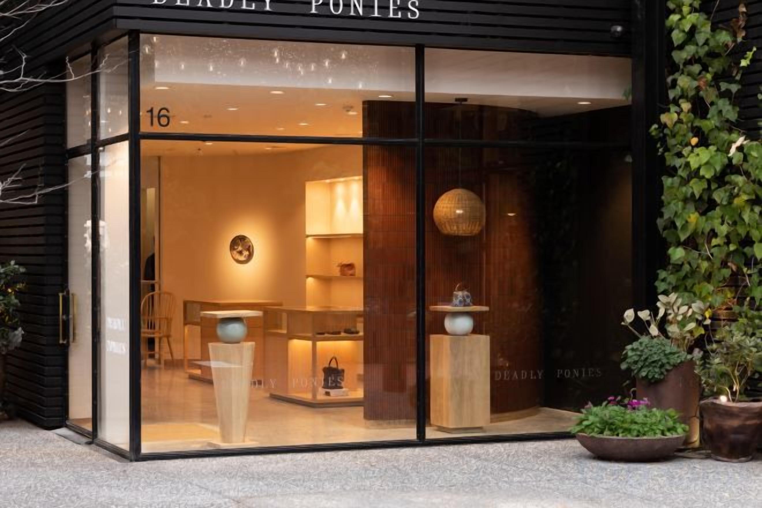 Fachada de loja com vidro, interior em madeira e uma placa com a inscrição 'BEARLEY PONTES'.