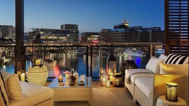 A balcony with a view of the city skyline and a body of water. - Point Residence (Auckland)