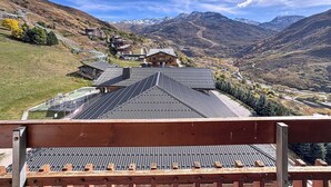 A mountain resort with a ski lift, chalet-style buildings, and a view of snow-capped mountains.