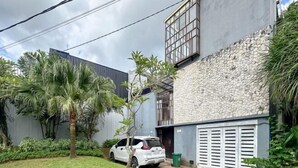 Un bâtiment moderne avec une façade en pierre, un garage et une voiture garée.