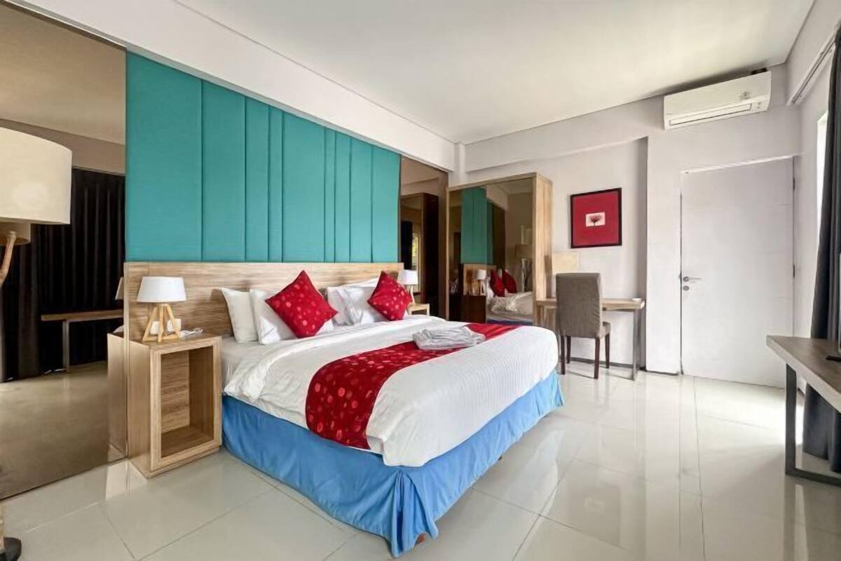Una habitación de hotel moderna con una cama grande, un escritorio y una silla.