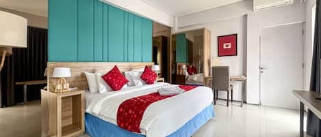 A modern hotel room with a large bed, a desk, and a chair.