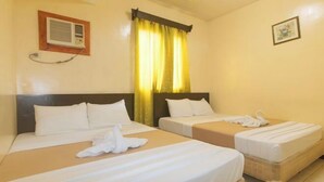 Een hotelkamer met twee bedden, een wandairconditioner, een gordijn en een ingelijste foto.
