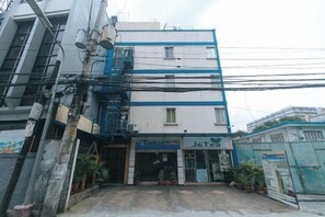 Un edificio con un letrero de J&Tea, varios pisos y una escalera.