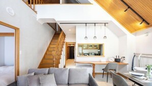Un interior moderno con sofá, mesa de comedor y zona de cocina.