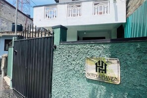 A gated area with a sign reading 'SURIYA HAVEN' on a textured wall. - Suriya Haven Homestay (Badulla)