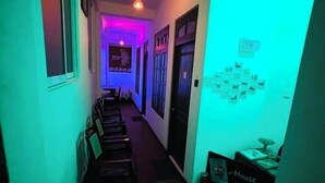 A hallway with chairs lined up, a wall with pictures, and a sign that says 'House.' - Suriya Haven Homestay (Badulla)
