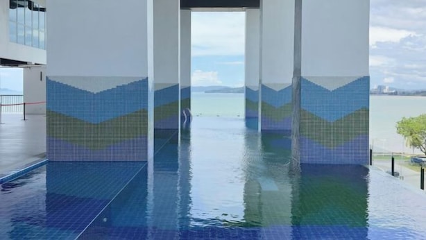 Een binnenzwembad met betegelde muren en een helder uitzicht op zee.