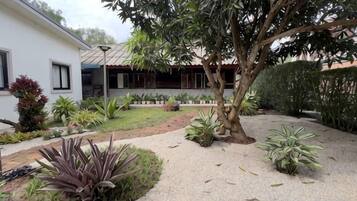 A residential property with a garden, a pathway, and a house with a tiled roof.
