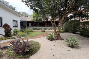 A residential property with a garden, a pathway, and a house with a tiled roof.