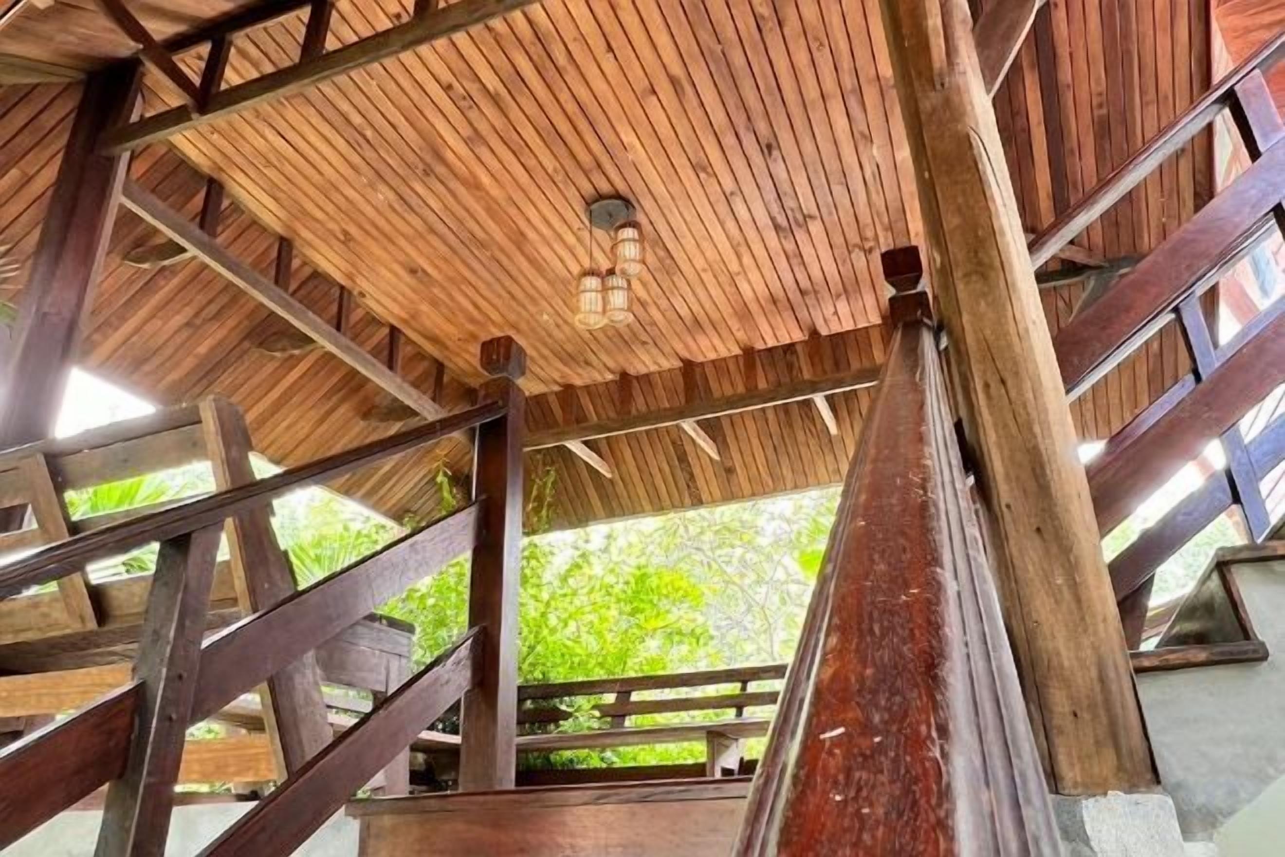 A wooden structure with a sloped roof and a lantern hanging from the ceiling.