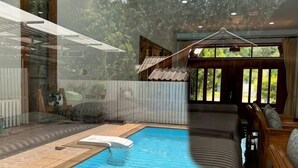 A swimming pool with a hot tub, a sunbed, and a view of the outdoors. - Pikul Homestay (Hat Yai)