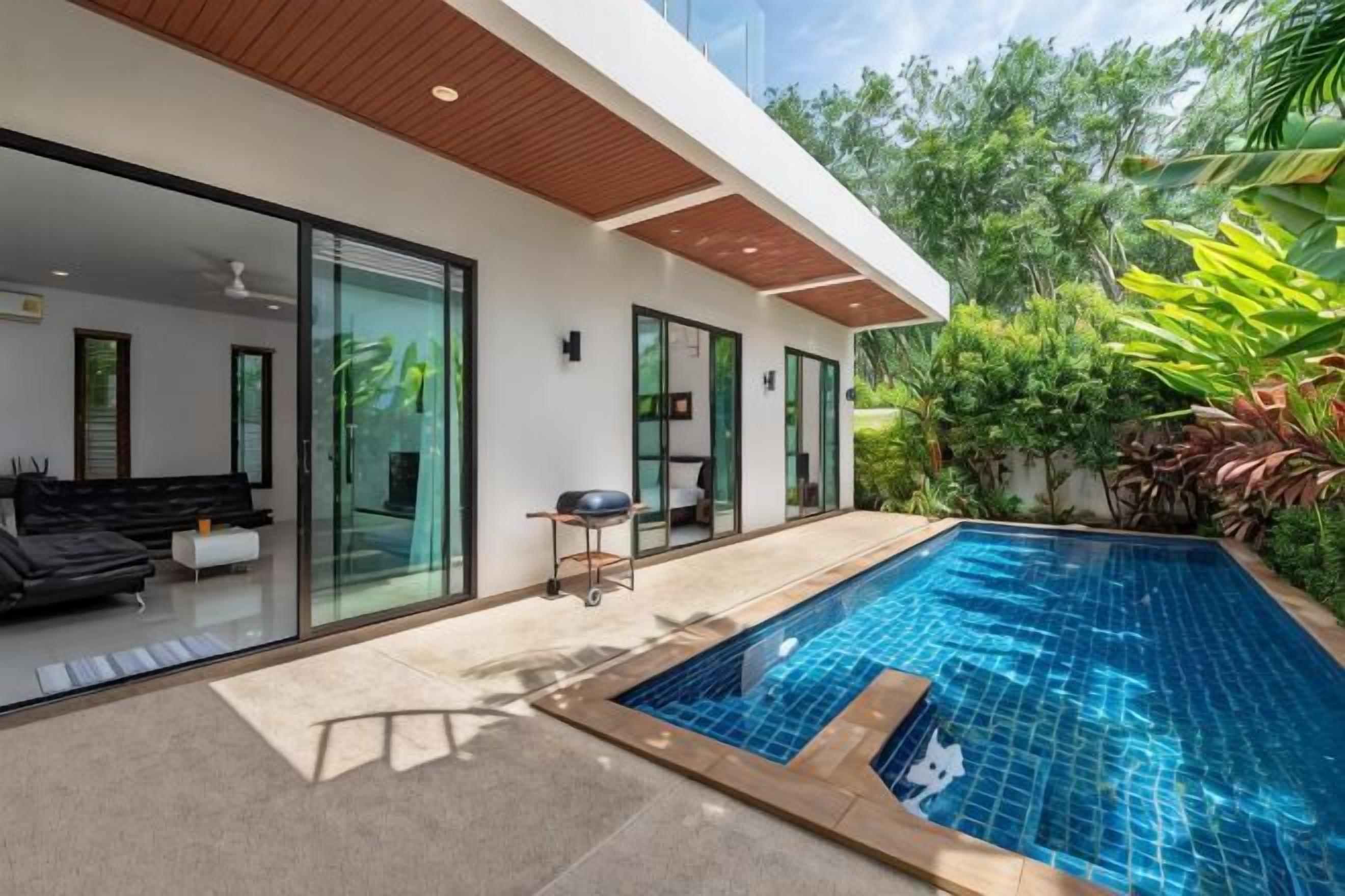 A modern house with a swimming pool, glass doors, and outdoor furniture.