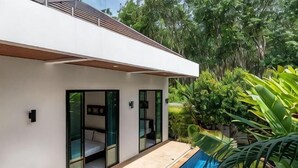 Een modern huis met een zwembad, glazen deuren en een patio.