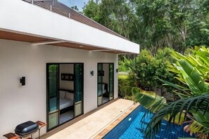 Una casa moderna con piscina, porte in vetro e un'area patio.