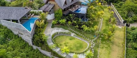 Un grand complexe hôtelier comprenant plusieurs bâtiments, une piscine et une végétation luxuriante.