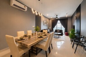 A modern dining area with a wooden table, white chairs, and a ceiling fan. - Twin Galaxy Residences (Johor Bahru)