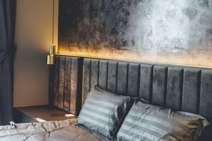 A bed with a headboard, a bedside table, and a wall with a textured pattern. - Twin Galaxy Residences (Johor Bahru)