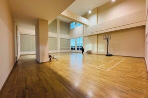 An indoor basketball court with a wooden floor and a basketball hoop. - Twin Galaxy Residences (Johor Bahru)