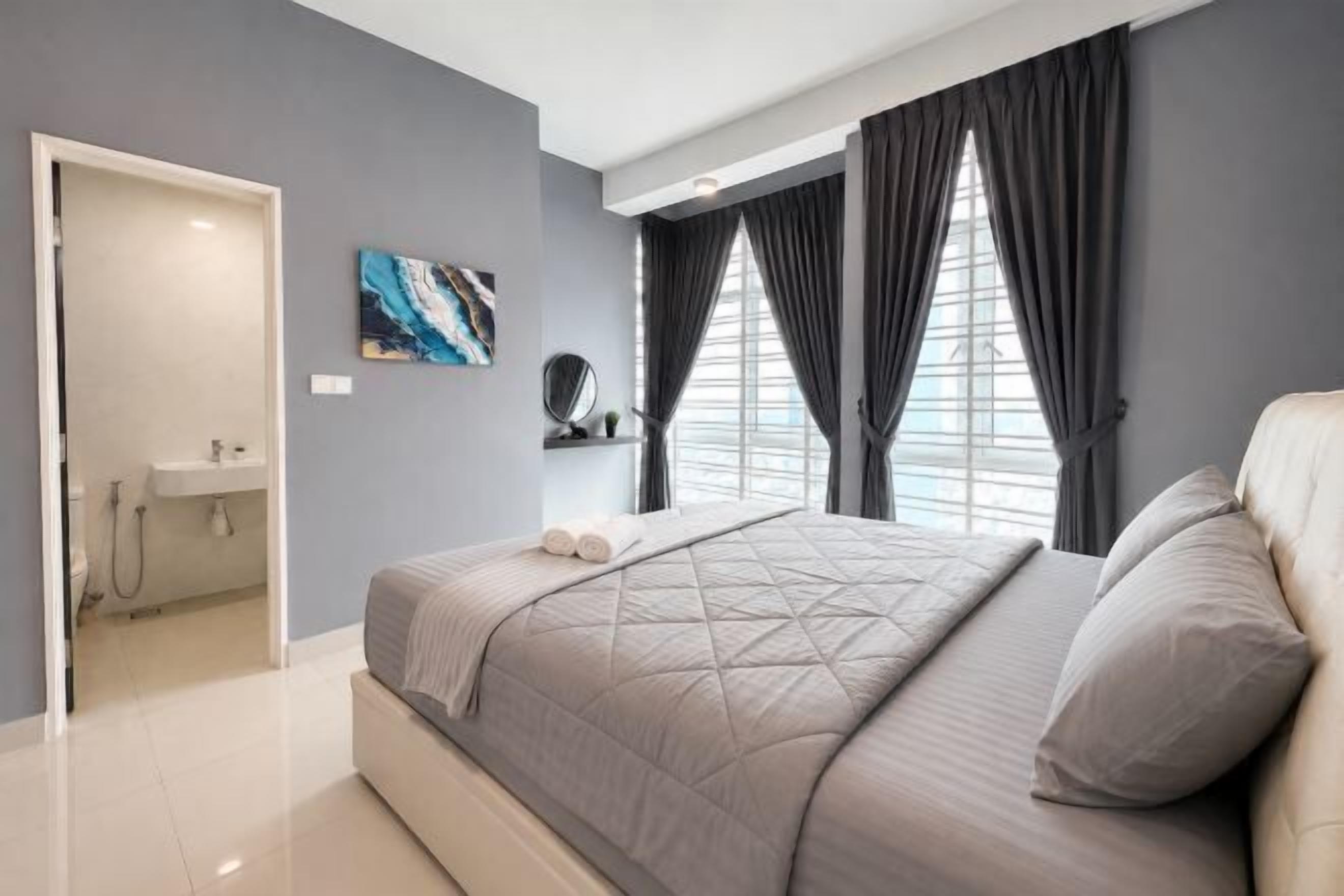 A modern bedroom with a large bed, a bathroom with a shower, and a view through the window.