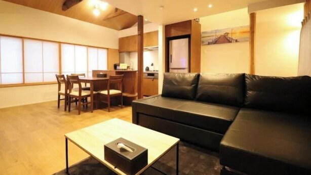 A modern living room with a sofa, a dining table, and chairs. - H-Shinsaibashi (Osaka)