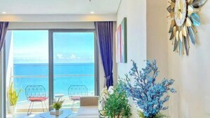 A modern room with a large window, a decorative wall clock, and a view of the sea. - The Song Vung Tau - Hong Hanh Apartments (Vung Tau)