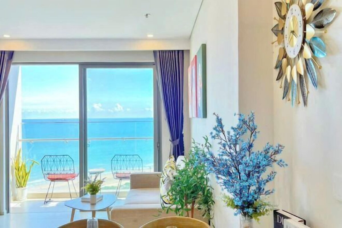 A modern room with a large window, a decorative wall clock, and a view of the sea.