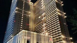 A high-rise building with multiple floors, each with balconies. The building is illuminated at night, highlighting its architectural features. - The Song Vung Tau - Hong Hanh Apartments (Vung Tau)