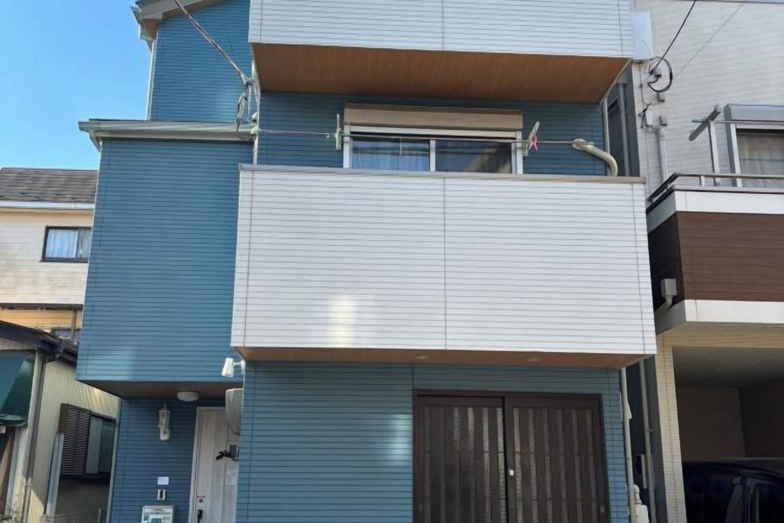 A multi-story residential building with a balcony on the upper floor.