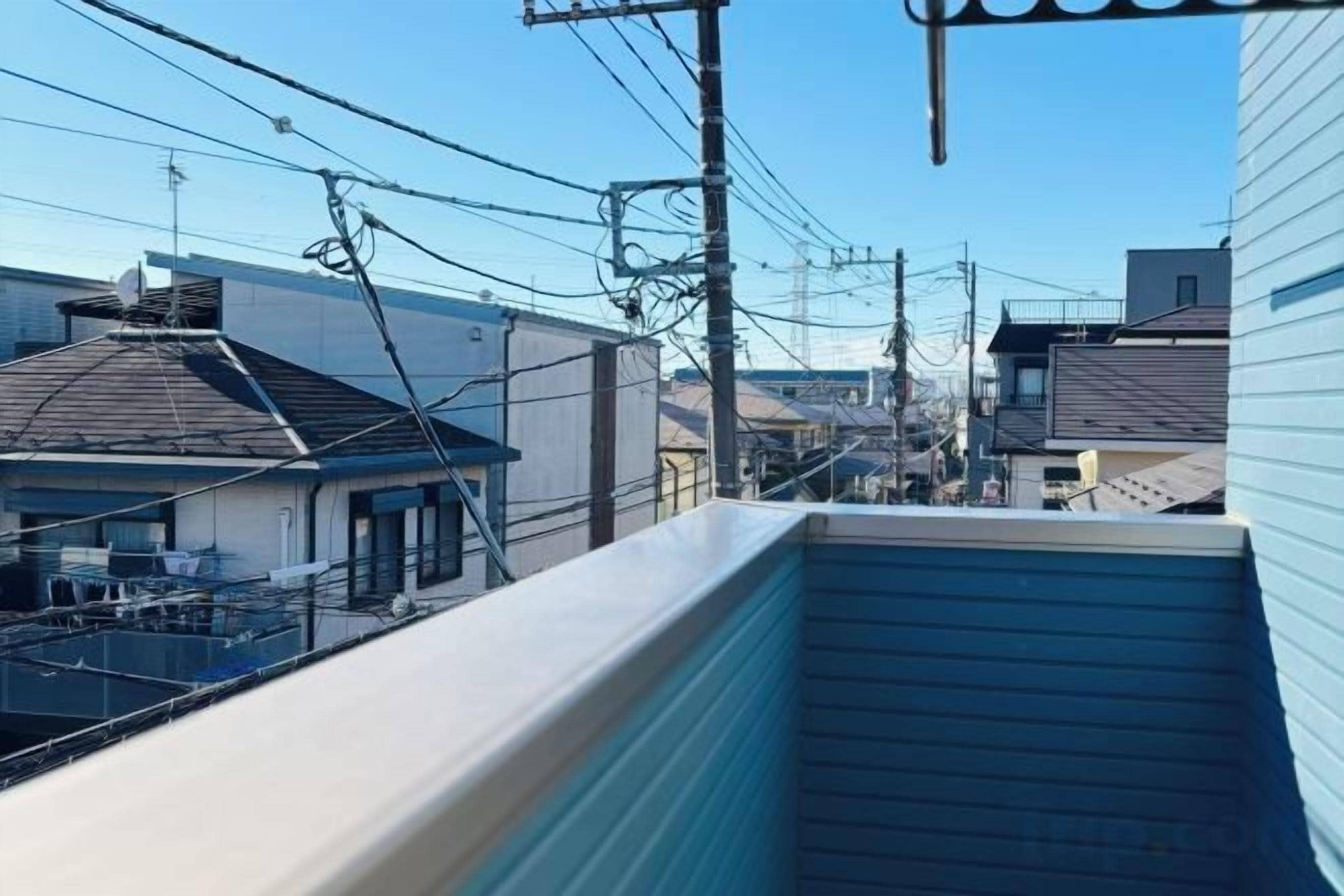 A residential area with multiple houses, power lines, and a clear sky.