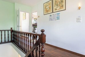 A staircase with a wooden handrail and a light green wall. - Friend House BKK (Bangkok)